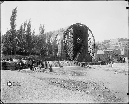 Hamwi women and girls wash clothes in front of noria al-Muhammadiyah (circa 1898-1914)